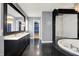 Modern bathroom featuring a double vanity, stylish lighting, a soaking tub, and a glass-enclosed shower at 4726 Ellery Ln, Indianapolis, IN 46250