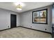 Cozy bedroom featuring neutral carpeting, a window, and a dark-colored door and trim at 4726 Ellery Ln, Indianapolis, IN 46250