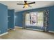 Comfortable bedroom with ample natural light, blue walls, and a ceiling fan for added comfort at 4726 Ellery Ln, Indianapolis, IN 46250