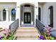A welcoming front entrance with decorative potted plants, featuring a detailed doorway and arched windows at 4726 Ellery Ln, Indianapolis, IN 46250