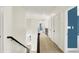 Bright hallway with neutral carpet and white doors, leading to various rooms in the home at 4726 Ellery Ln, Indianapolis, IN 46250