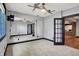 Spacious living room with large mirror and ceiling fan, leading to a room with brick walls at 4726 Ellery Ln, Indianapolis, IN 46250