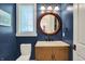 Charming powder room with marble countertop, statement mirror and blue painted walls at 4726 Ellery Ln, Indianapolis, IN 46250