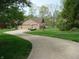 Wide driveway leading to a brick home, with a glimpse of the lake through the trees at 4806 Krestridge E Ct, Bargersville, IN 46106