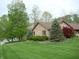 Brick home with mature trees, manicured lawn, and view of the lake at 4806 Krestridge E Ct, Bargersville, IN 46106