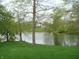 A tranquil lake scene with trees lining the shore and a glimpse of a house at 4806 Krestridge E Ct, Bargersville, IN 46106