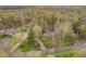 Aerial view of a house nestled among lush greenery with a driveway and surrounding trees at 5001 Woodrose Ln, Anderson, IN 46011