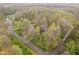 Aerial view of a property with mature trees, a winding driveway, and lush surroundings at 5001 Woodrose Ln, Anderson, IN 46011