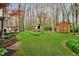 Expansive backyard featuring a playhouse, shed, and lush lawn surrounded by mature trees at 5001 Woodrose Ln, Anderson, IN 46011