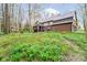 Scenic view of a Tudor-style home with a well-maintained lawn and wooded surroundings at 5001 Woodrose Ln, Anderson, IN 46011