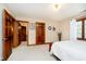 Bedroom with wood trim, white bedding, neutral walls and carpet, and wood doors at 5001 Woodrose Ln, Anderson, IN 46011