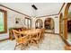 Bright dining room boasts a wooden table, chairs, wainscoting, and an adjacent living space at 5001 Woodrose Ln, Anderson, IN 46011