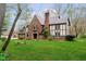 Charming Tudor-style home with brick and stucco exterior, surrounded by a green lawn at 5001 Woodrose Ln, Anderson, IN 46011