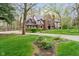 Well-maintained brick and Tudor home with a circular driveway and manicured landscaping at 5001 Woodrose Ln, Anderson, IN 46011