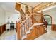 Grand foyer featuring a wooden staircase, tile flooring, and arched doorways at 5001 Woodrose Ln, Anderson, IN 46011