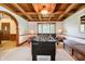 Well-lit game room with a coffered ceiling and a view of the backyard at 5001 Woodrose Ln, Anderson, IN 46011