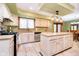 Bright kitchen with tile floors featuring a center island, stainless dishwasher, and window view at 5001 Woodrose Ln, Anderson, IN 46011