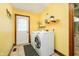 The laundry room has a washer and dryer with shelf decor and a door to the backyard at 5001 Woodrose Ln, Anderson, IN 46011