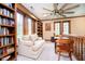 Sitting room featuring a comfortable sofa, bookshelves, a small desk, and a ceiling fan at 5001 Woodrose Ln, Anderson, IN 46011