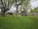 Spacious backyard with mature trees and a wooden shed offering storage solutions at 5107 Saddle Ln, Anderson, IN 46013