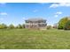 Expansive backyard with a well-maintained lawn, trees, and a two-story home with a deck at 5141 S Cobblestone Dr, Zionsville, IN 46077