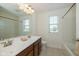 Bathroom with dual sinks, wood cabinets, and a combined shower-tub with neutral tile flooring at 5141 S Cobblestone Dr, Zionsville, IN 46077