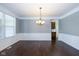 Formal dining room with hardwood floors, wainscotting, chandelier, and access to kitchen at 5141 S Cobblestone Dr, Zionsville, IN 46077