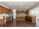Modern kitchen featuring stainless steel appliances, granite countertops, wood cabinets, and a center island at 5141 S Cobblestone Dr, Zionsville, IN 46077