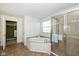Main bathroom featuring a tub with a window and a glass door shower with tile surround at 5141 S Cobblestone Dr, Zionsville, IN 46077