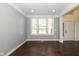Room with gray walls, white trim, and hardwood floors next to the home's foyer at 5141 S Cobblestone Dr, Zionsville, IN 46077