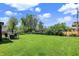 Spacious backyard featuring a lush green lawn, mature trees, and a patio set for outdoor enjoyment at 5354 Brendon Park Dr, Indianapolis, IN 46226