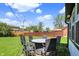 Large backyard featuring a stone patio set with chairs, a green lawn, and a wood fence at 5354 Brendon Park Dr, Indianapolis, IN 46226