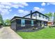 Exterior view of black painted brick and vinyl siding home with a long paved driveway and green grass at 5354 Brendon Park Dr, Indianapolis, IN 46226
