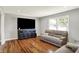 Cozy living room featuring gleaming hardwood floors, a comfortable sofa, and a large screen television at 5354 Brendon Park Dr, Indianapolis, IN 46226