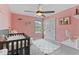 This cozy bedroom has pink walls, carpeted floors, shelving and a small window to let the sunshine in at 5363 Citadel Dr, Noblesville, IN 46062