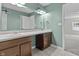 Bathroom boasts dual sinks with a large mirror, warm toned vanity, and soothing green walls at 5465 Tanglewood Ln, Whitestown, IN 46075