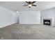 Open living room with carpeted floors, ceiling fan, and a corner fireplace feature at 5465 Tanglewood Ln, Whitestown, IN 46075