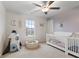 Bright bedroom with a crib, rocket toy, and natural light from the window at 5845 Cresswell Ln, Whitestown, IN 46075