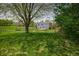 Beautiful fenced backyard with mature trees, a swing, and an outdoor seating area at 6209 Amber Valley Ln, Indianapolis, IN 46237
