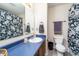 This bathroom features a shower with patterned curtain, a vanity with sink and mirror and an adjacent toilet at 6209 Amber Valley Ln, Indianapolis, IN 46237