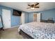 This bedroom features a ceiling fan and a bed with a floral patterned bedspread. A door leads to another room at 6209 Amber Valley Ln, Indianapolis, IN 46237
