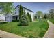 Inviting home featuring a lush green lawn with mature trees and a two car garage at 6209 Amber Valley Ln, Indianapolis, IN 46237