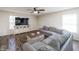 Comfortable living room featuring a large grey sofa, a ceiling fan, and hardwood floors at 6209 Amber Valley Ln, Indianapolis, IN 46237