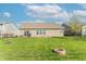 Spacious backyard with a brick home featuring a patio, a grassy area, and a fire pit for entertaining at 6229 Farlin Dr, Whitestown, IN 46075