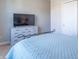A bright bedroom is furnished with a dresser topped with a TV and a comfortable bed at 6229 Farlin Dr, Whitestown, IN 46075
