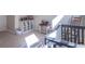 Bedroom featuring a gray and white color scheme, cubbies, and a rocking chair near a crib and ABC rug at 6229 Farlin Dr, Whitestown, IN 46075