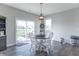 Bright dining room with hardwood floors, white chairs, and sliding glass doors to the backyard at 6229 Farlin Dr, Whitestown, IN 46075