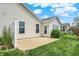 Exterior home shot with patio and well-manicured lawn complemented by garden area with plantings at 6241 Colonial Dr, Whitestown, IN 46075