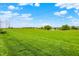 Expansive green space with a pond, walking path, and powerlines against a partially cloudy sky at 6241 Colonial Dr, Whitestown, IN 46075