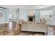 Open-concept living room showcasing hardwood floors, neutral decor, a fireplace and a seamless flow into the entryway at 6241 Colonial Dr, Whitestown, IN 46075